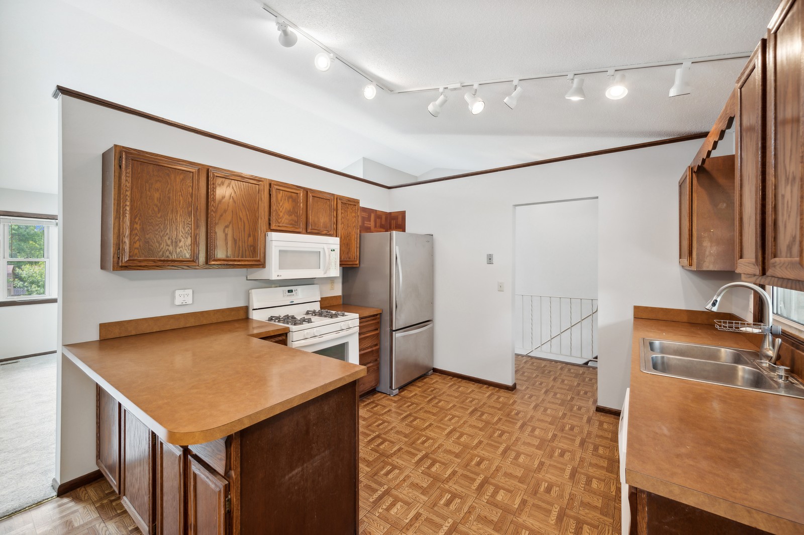 Bright kitchen at Blossom Hill Assisted Living featuring a dining nook and open shelving for residents' convenience